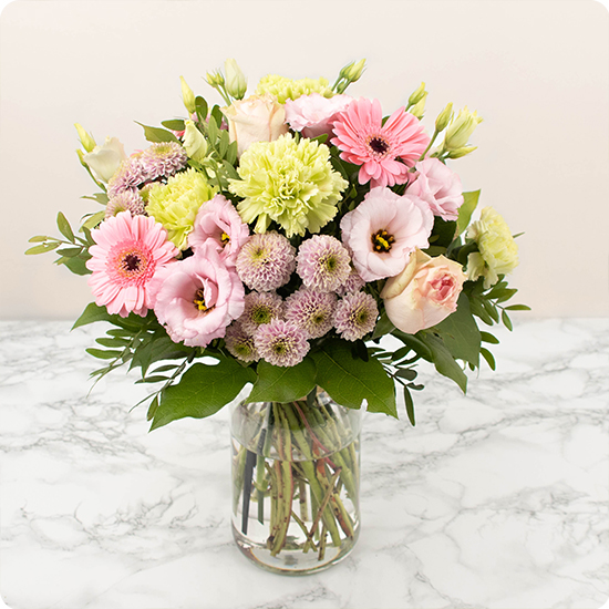 Composé avec soin par un artisan fleuriste local, ce bouquet raffiné et gracieux est constitué de roses et de délicates fleurs de saison dans des nuances de rose et de vert.